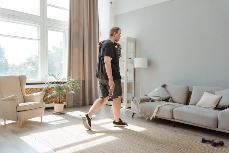 A Man In Black Outfit Exercising At Home
