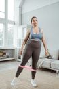 Woman in Blue Tank Top and Black Leggings Standing Near White Couch