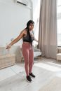 Woman in Black Tank Top and White Pants Holding White Plastic Basket