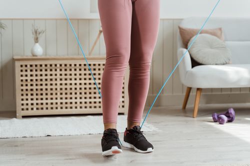 Free A plus size woman exercising with a jump rope in a cozy living room setting. Stock Photo