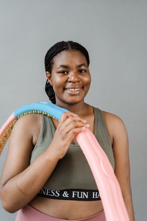 Free Joyful woman poses with a colorful hula hoop, embracing fitness and body positivity. Stock Photo