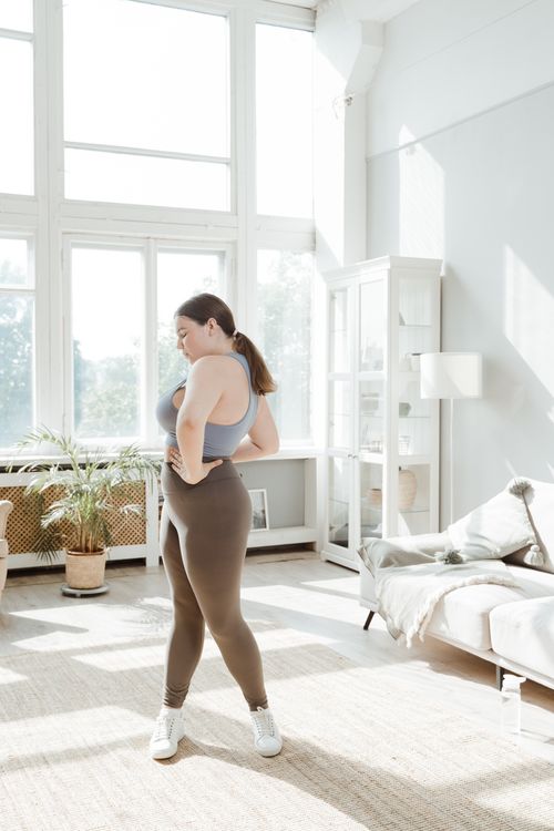 Free Confident plus size woman practicing yoga in a bright, serene living room. Stock Photo