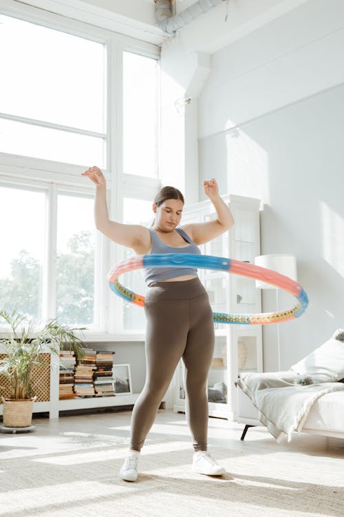 Free A Woman in Blue Tank Top a Using Hula Hoop Stock Photo