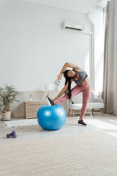A woman in activewear stretches with a yoga ball in a bright and airy living room.