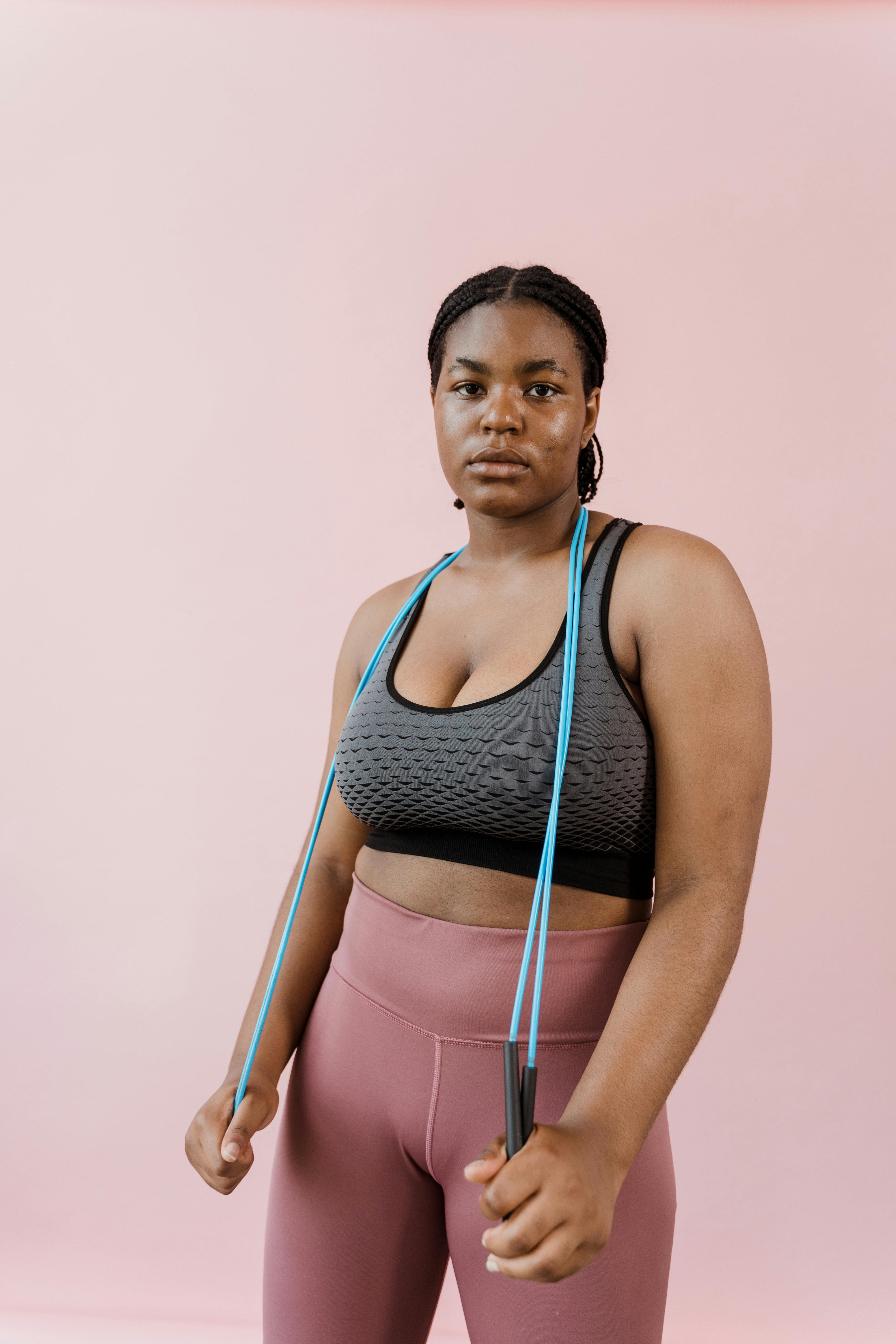 Woman in Gray Sports Bra and Pink Leggings Posing With A Skipping