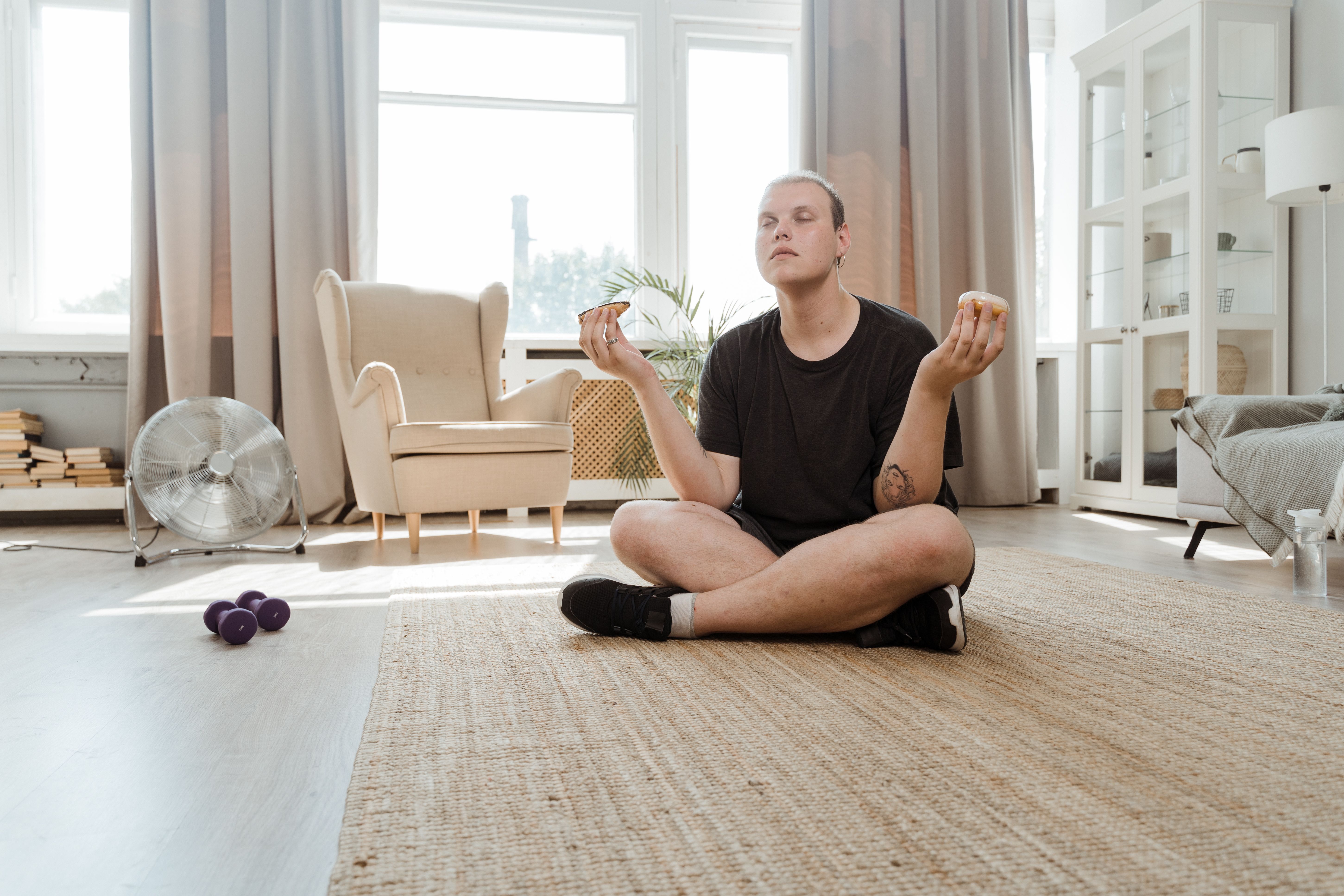 Pessoa praticando meditação ou mindfulness em casa, em busca de relaxamento e bem-estar.