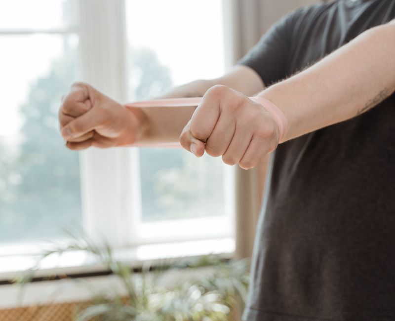 A person applying a balance patch on their arm before a workout.