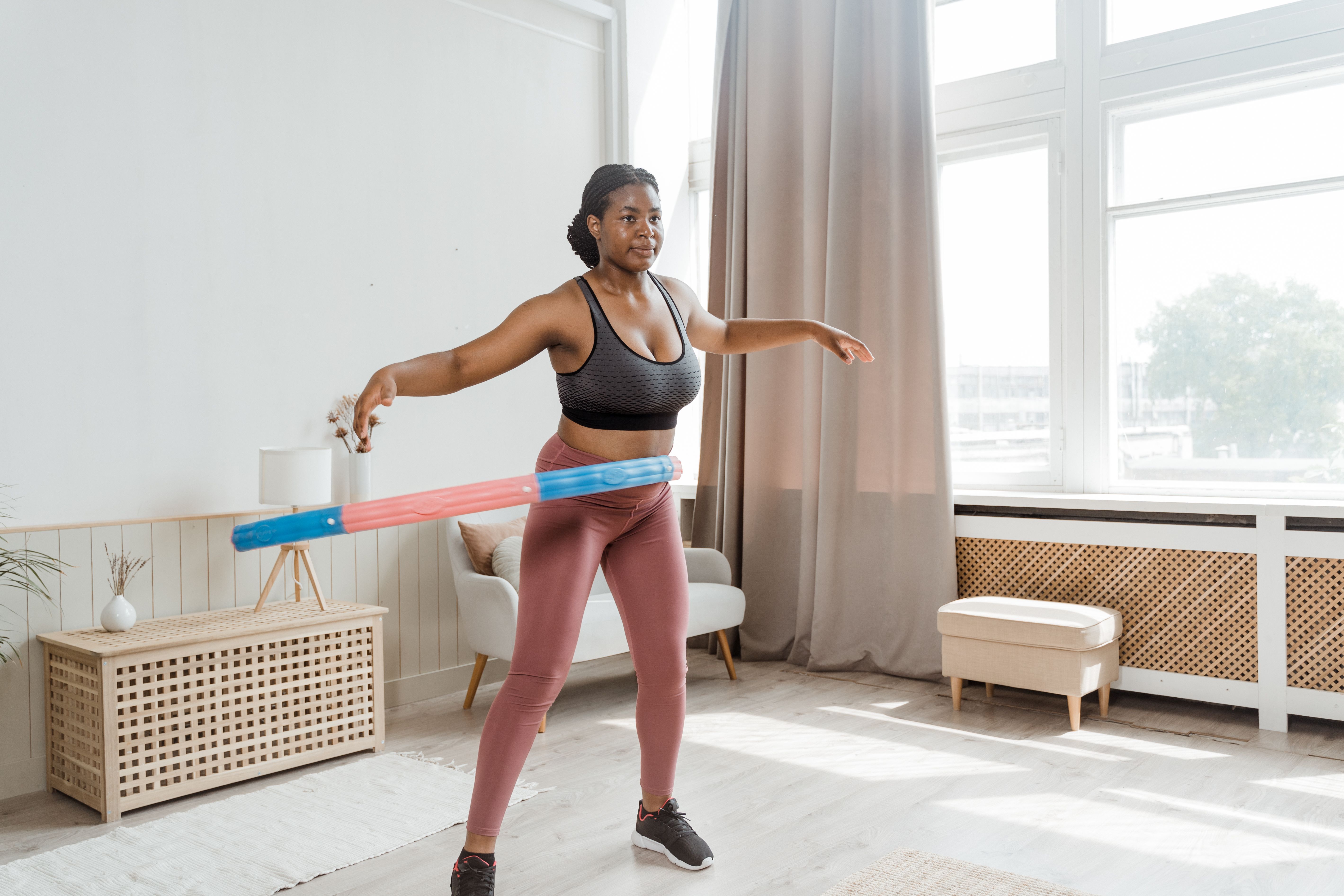 woman in black sports bra and blue denim shorts standing on white floor