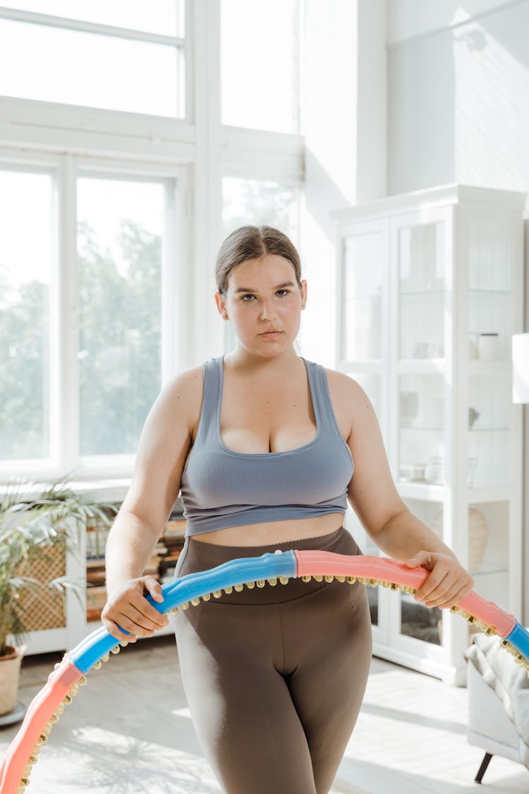 A Woman In Blue Sports Bra Holding A Hula Hoop