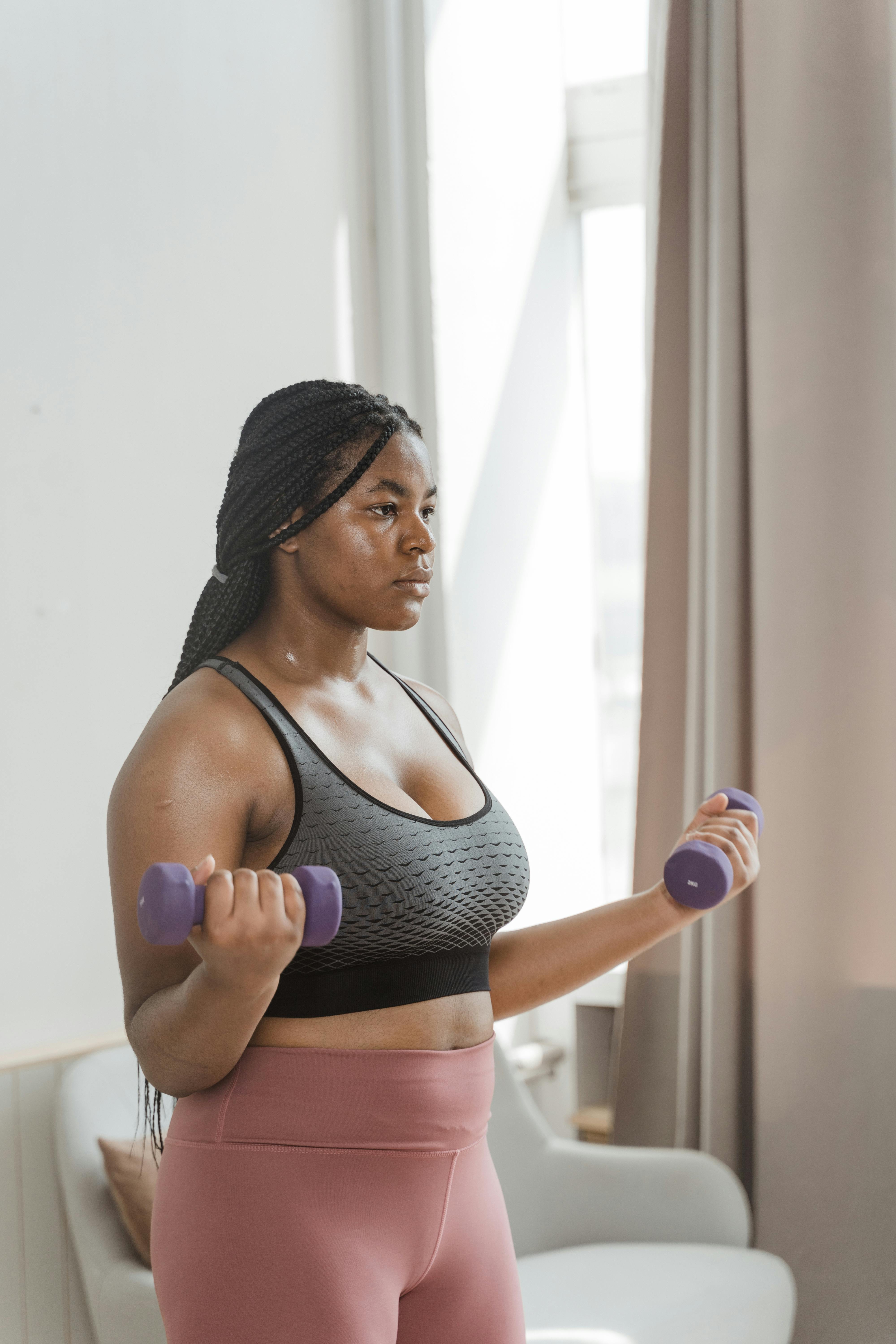 sweaty woman exercising using dumbbells