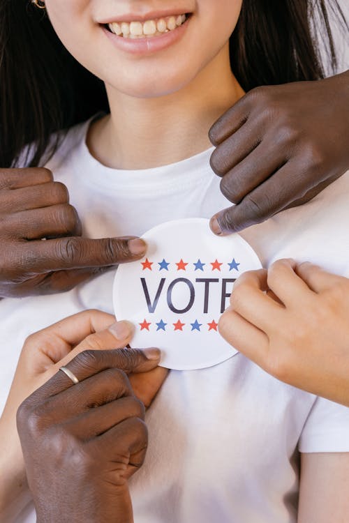 Close Up Photo of Voter's Badge Held by Hands