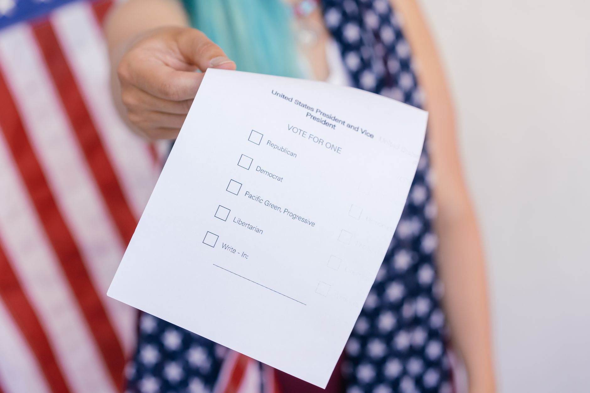 Close-up photo of a hand holding a US election voting ballot.