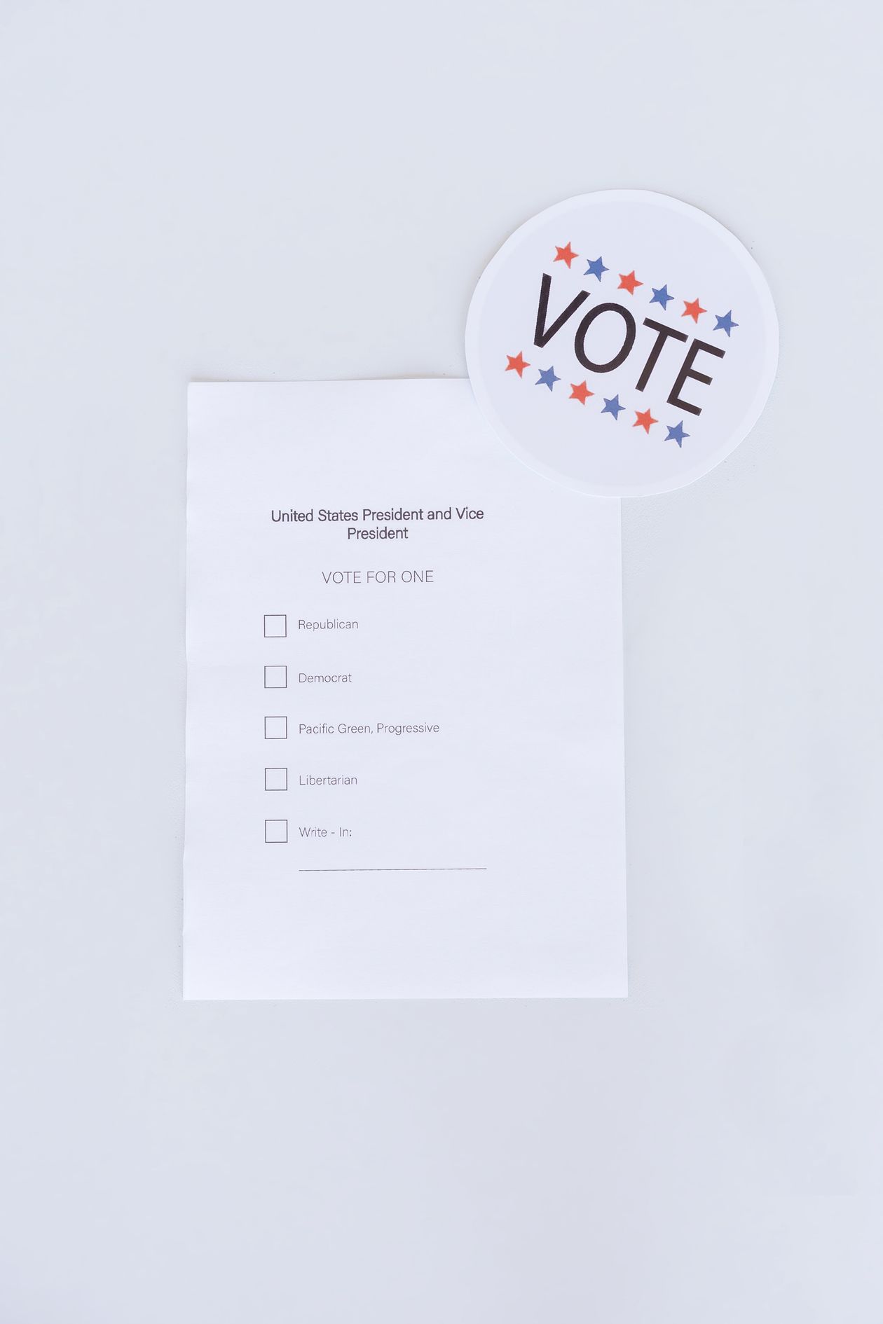 Ballot Paper and Vote Badge on White Surface