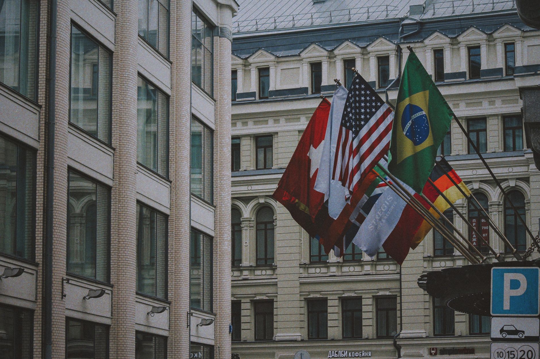 View of international flags outside an urban building in daylight, symbolizing global unity.
