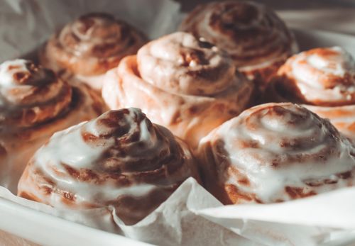 Free Close-up view of freshly baked cinnamon rolls with icing, perfect for dessert lovers. Stock Photo