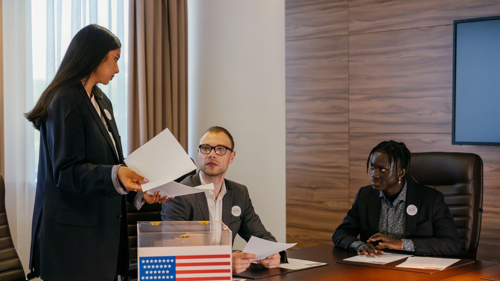 A diverse group of professionals deliberating in a conference room about election plans.
