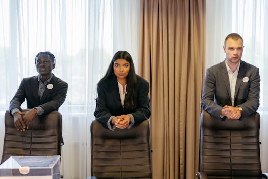 Three diverse professionals in suits in a conference room, expressing confidence and teamwork.