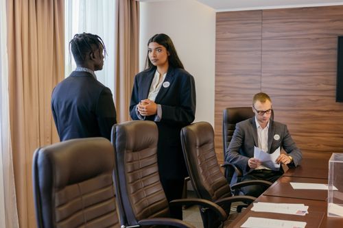 Free Three professionals discussing business strategy in a modern conference room. Stock Photo