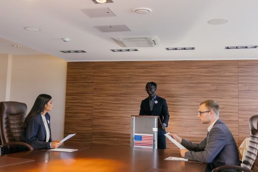 Business professionals engaged in a formal meeting, discussing key topics around a conference table.