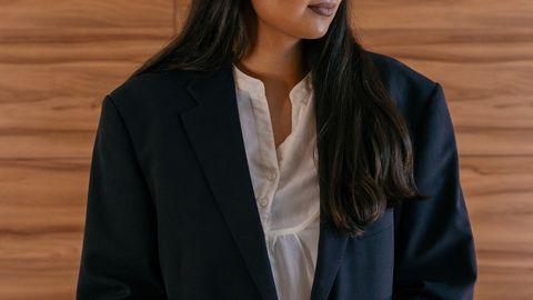 A professional woman speaking confidently at a podium indoors.