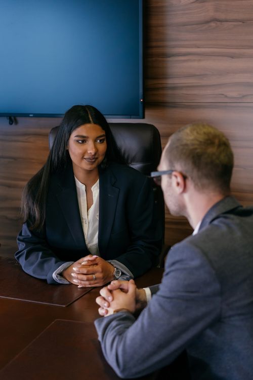 Free Two professionals in a business meeting discussing strategies at a wooden table. Stock Photo