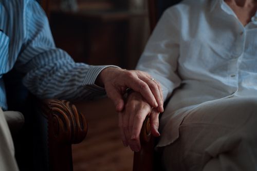 Free An intimate moment of an elderly couple holding hands, capturing love and companionship. Stock Photo