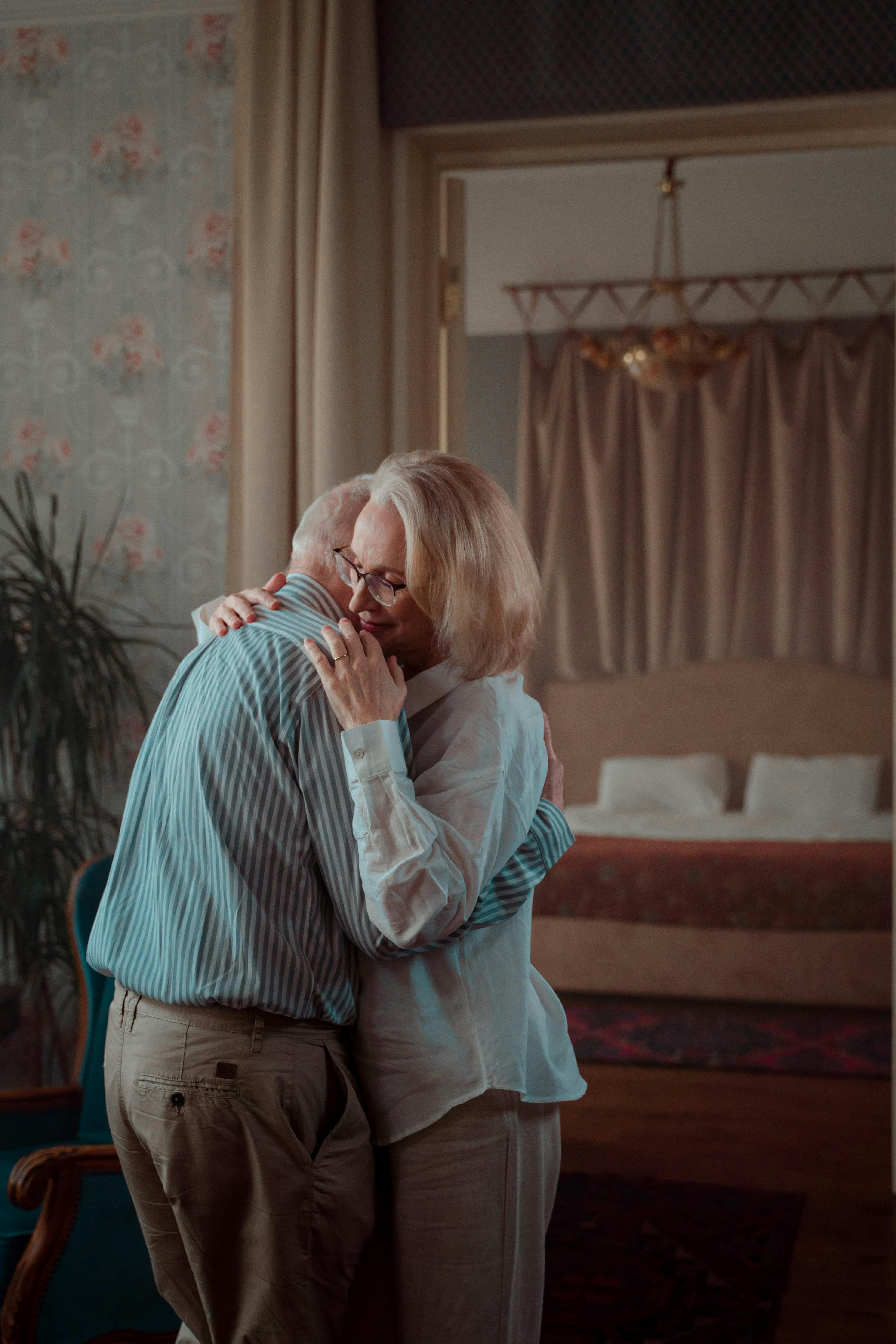 elderly couple hugging at home