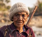 一位戴着羊毛帽的成熟女性特写肖像，凸显了她的智慧与阅历