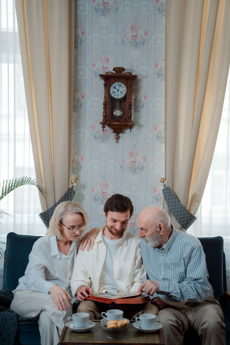 A Family Looking At A Photo Album