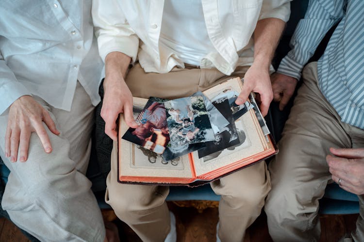 A Family Sitting Together Looking At Pictures