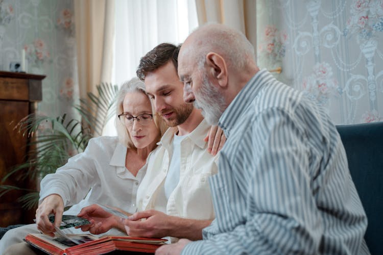 A Family Looking At A Photo Album