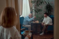 Man in White Dress Shirt Sitting on Chair