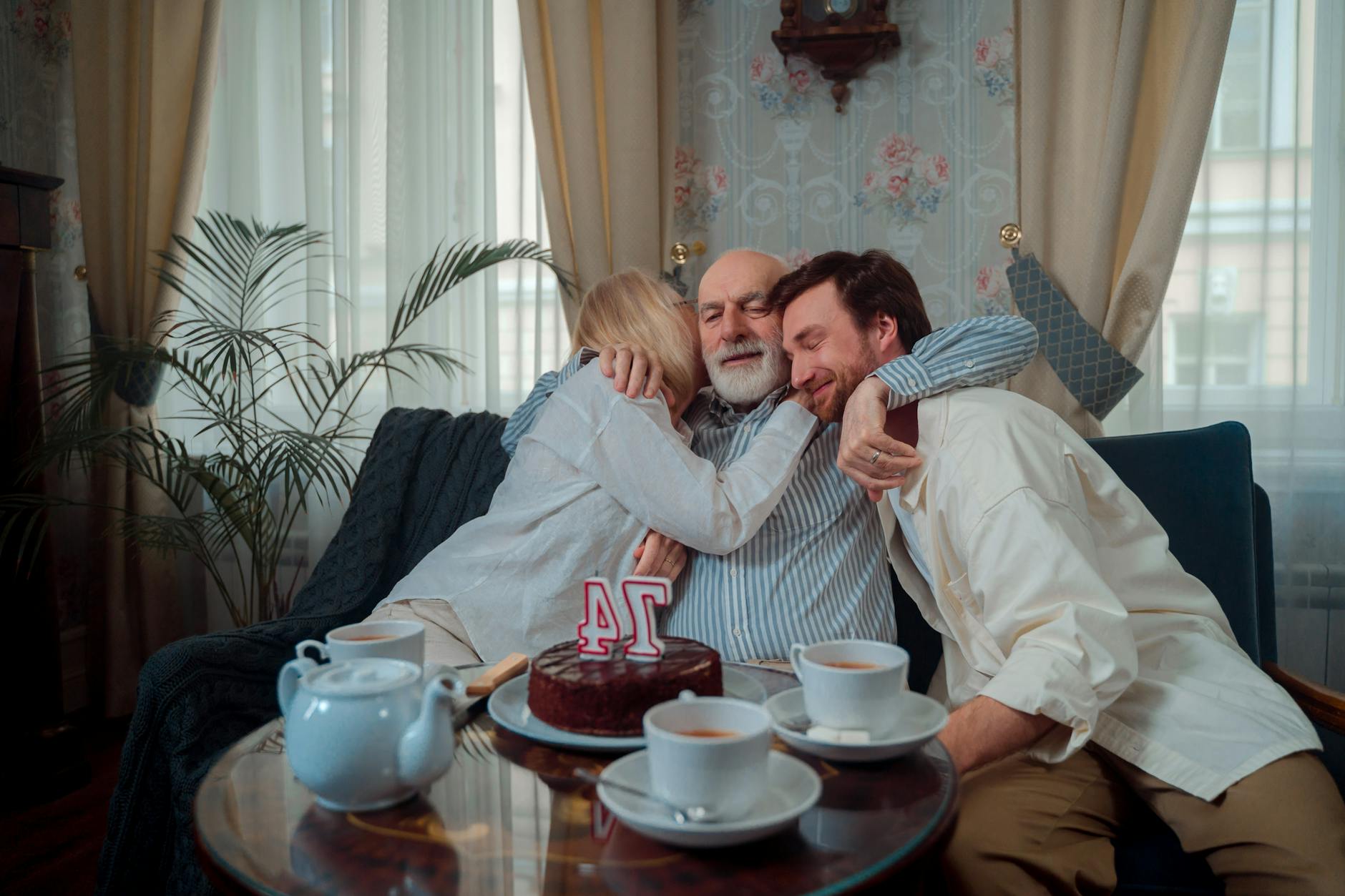 Warm family birthday celebration with cake and heartfelt hugs indoors.