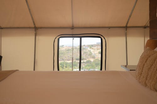 A Window by a Bed inside a Tent