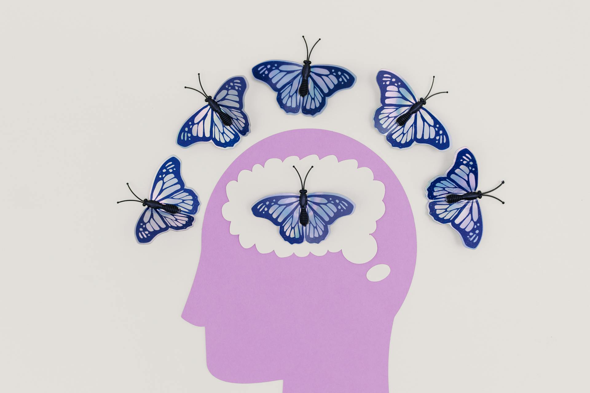 Illustration of a Head and Butterflies Around the Scalp and Inside the Brain