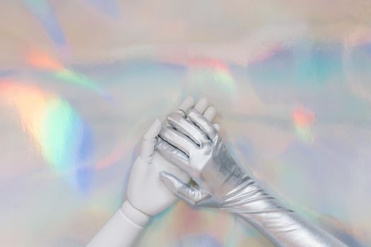 Close-up of a silver metallic glove on a colorful holographic background, evoking a futuristic theme. — photo by Tara Winstead