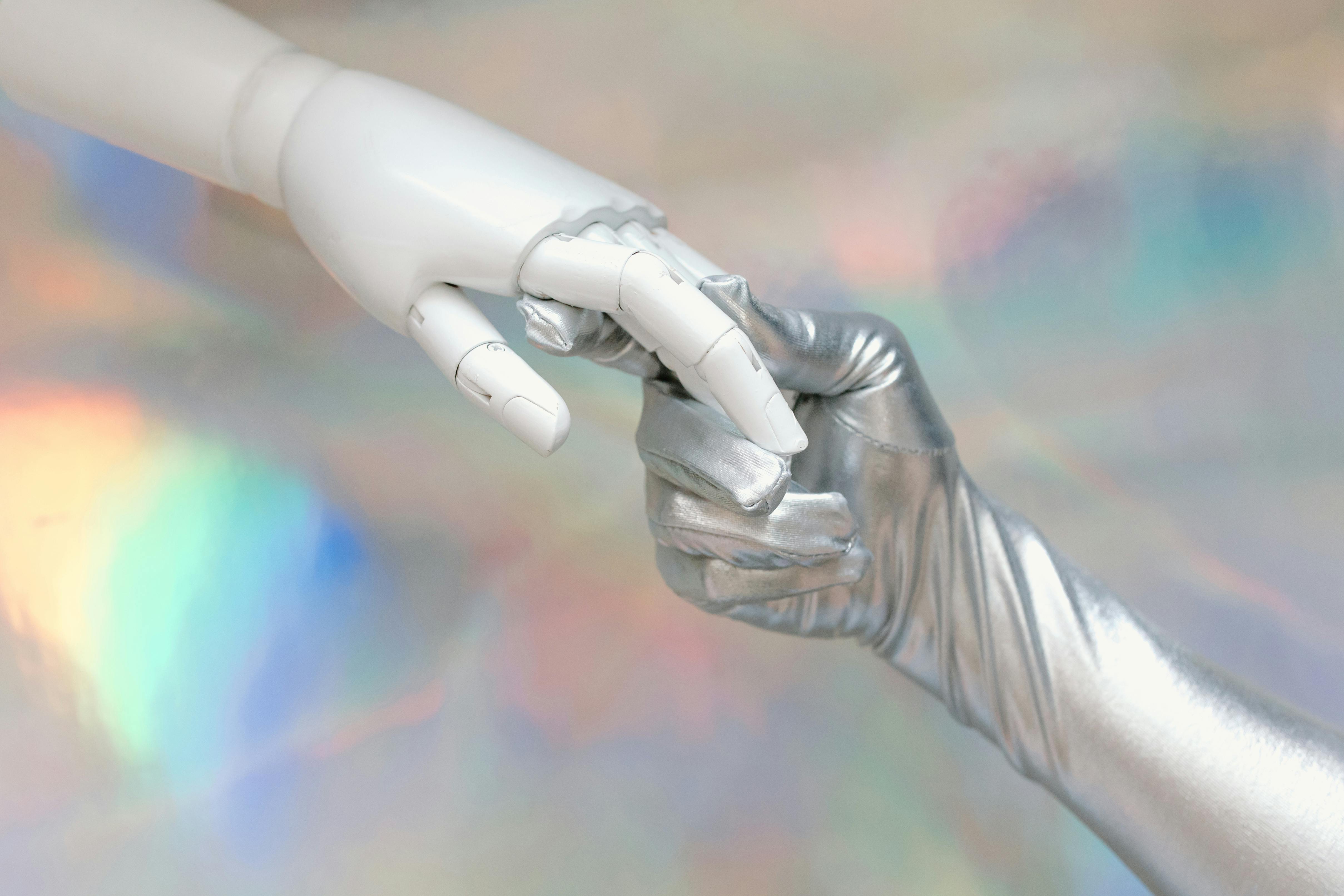 O poder do digital e da IA no empreendedorismo moderno 5 Close-up of a robot hand and silver-gloved hand touching, symbolizing human-robot connection.