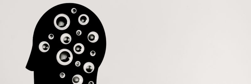 Abstract illustration of AI with silhouette head full of eyes, symbolizing observation and technology.