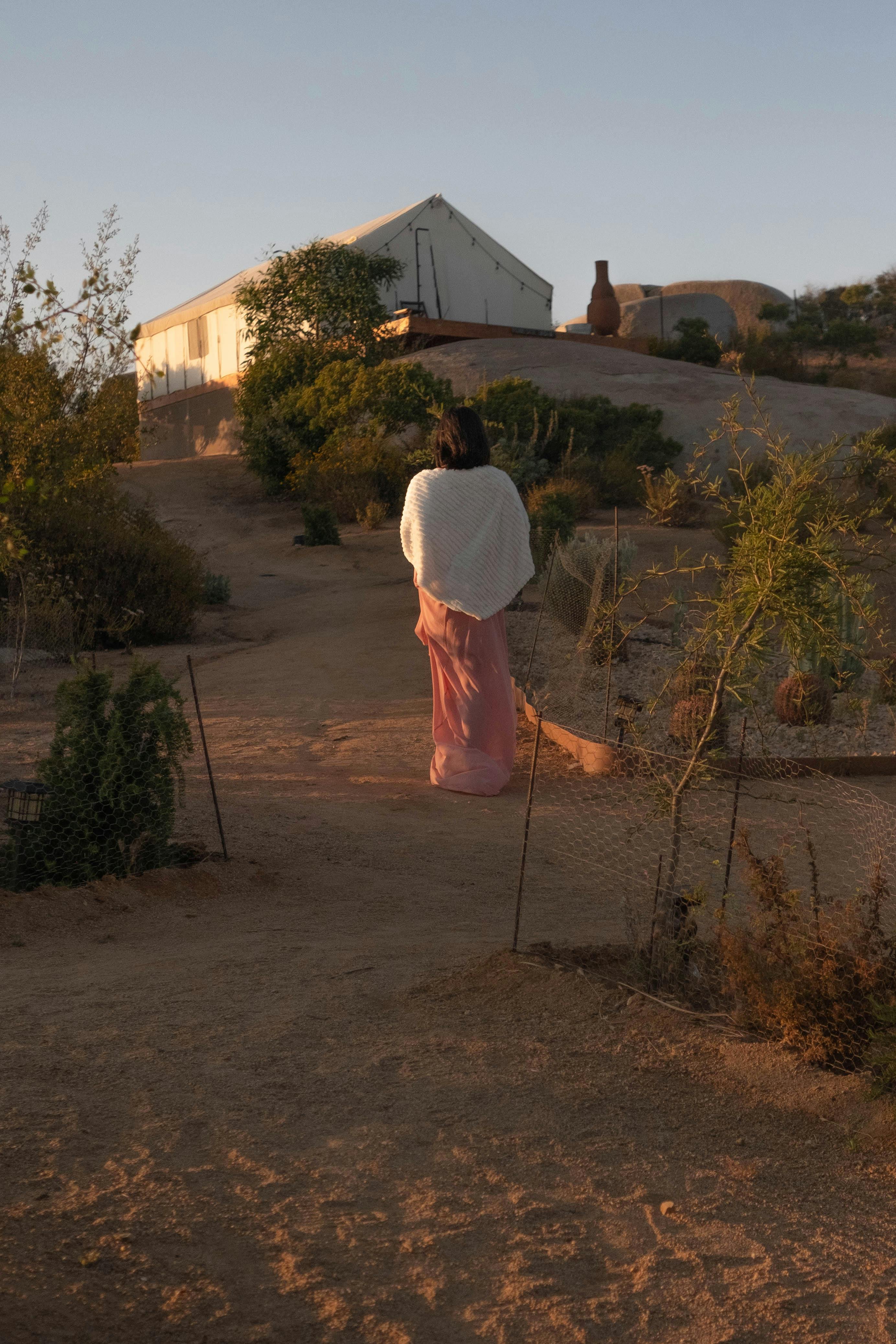 a woman standing near the green plants