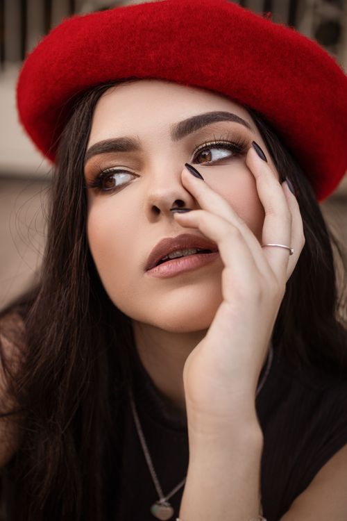 Free Elegant close-up portrait of a woman in a red beret, showcasing fashion and beauty. Stock Photo