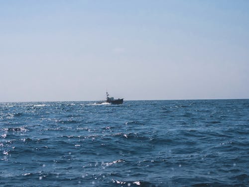 Free Fishing Boat Sails in an Ocean Stock Photo