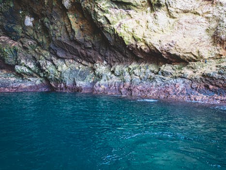Explore the breathtaking coastal cave with turquoise waters and rugged rock formations.