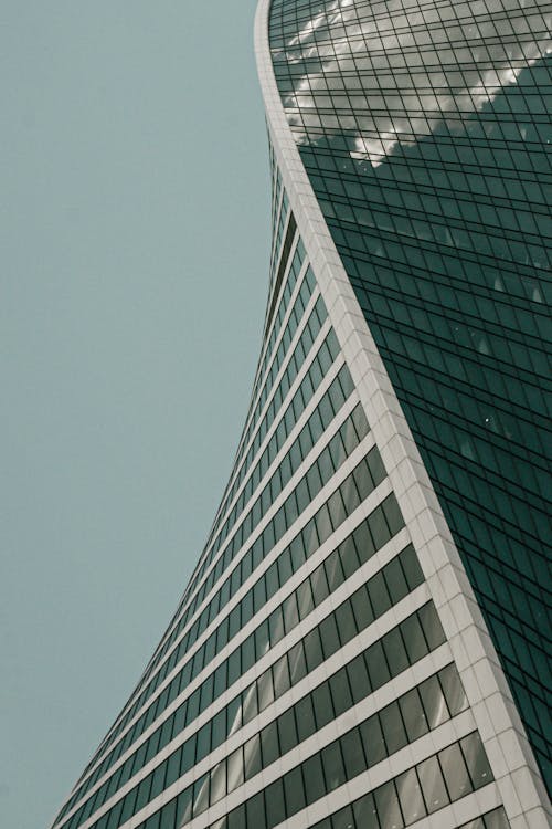 Free White Glass Skyscraper With Clouds Reflection  Stock Photo