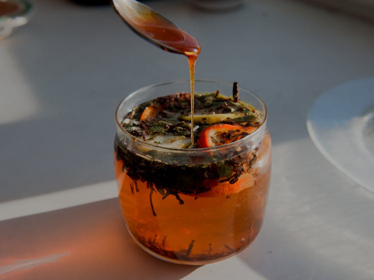 Pouring Honey In A Citrus Tea