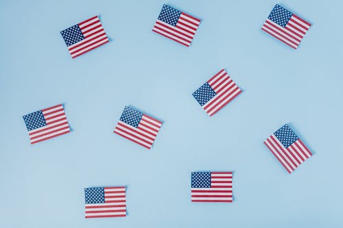 Free American Flags on Blue Pastel Background Stock Photo