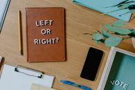 Black Iphone 5 Beside Brown Leather Bag on Brown Wooden Table