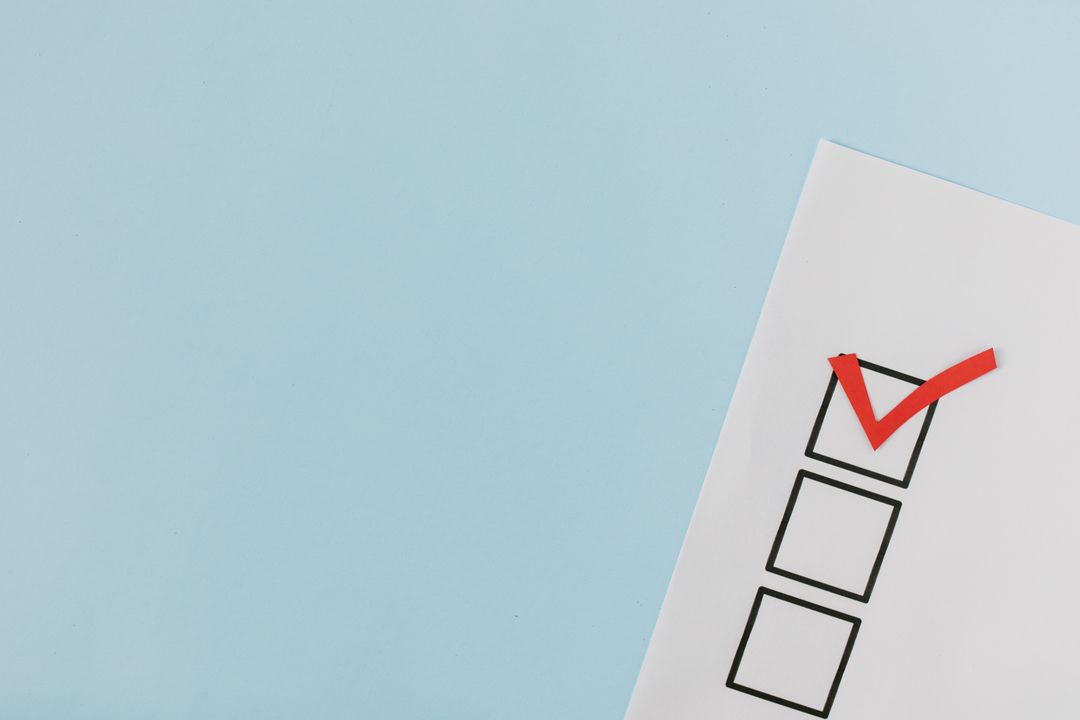 A checklist with a red checkmark symbolizing a completed task on a pastel blue background.