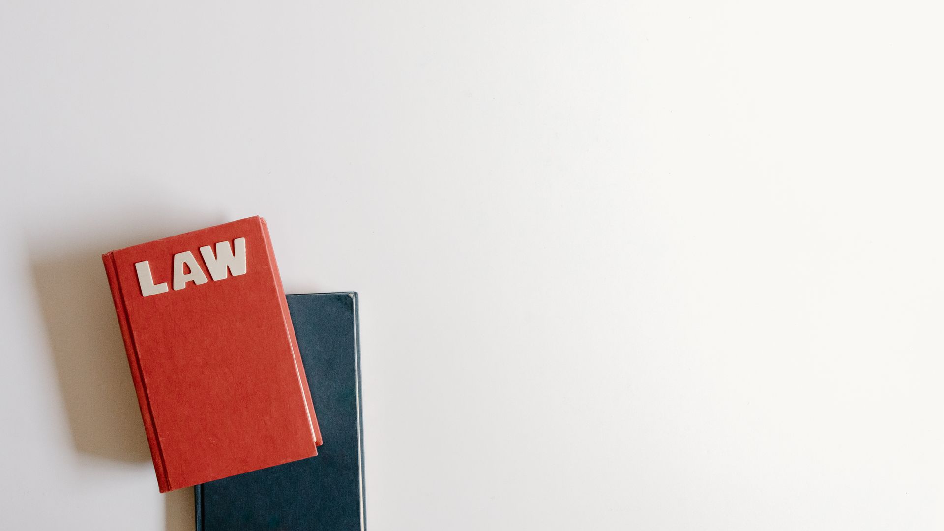 Is Modafinil Legal Online? Understanding the Legal Landscape Flat lay of a red law book and a blue book on a white background, perfect for legal themes — is modafinil legal online