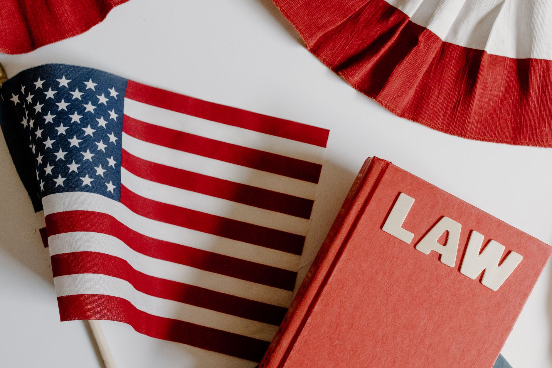 Patriotic scene with American flag and law book on a white background, symbolizing freedom and democracy.