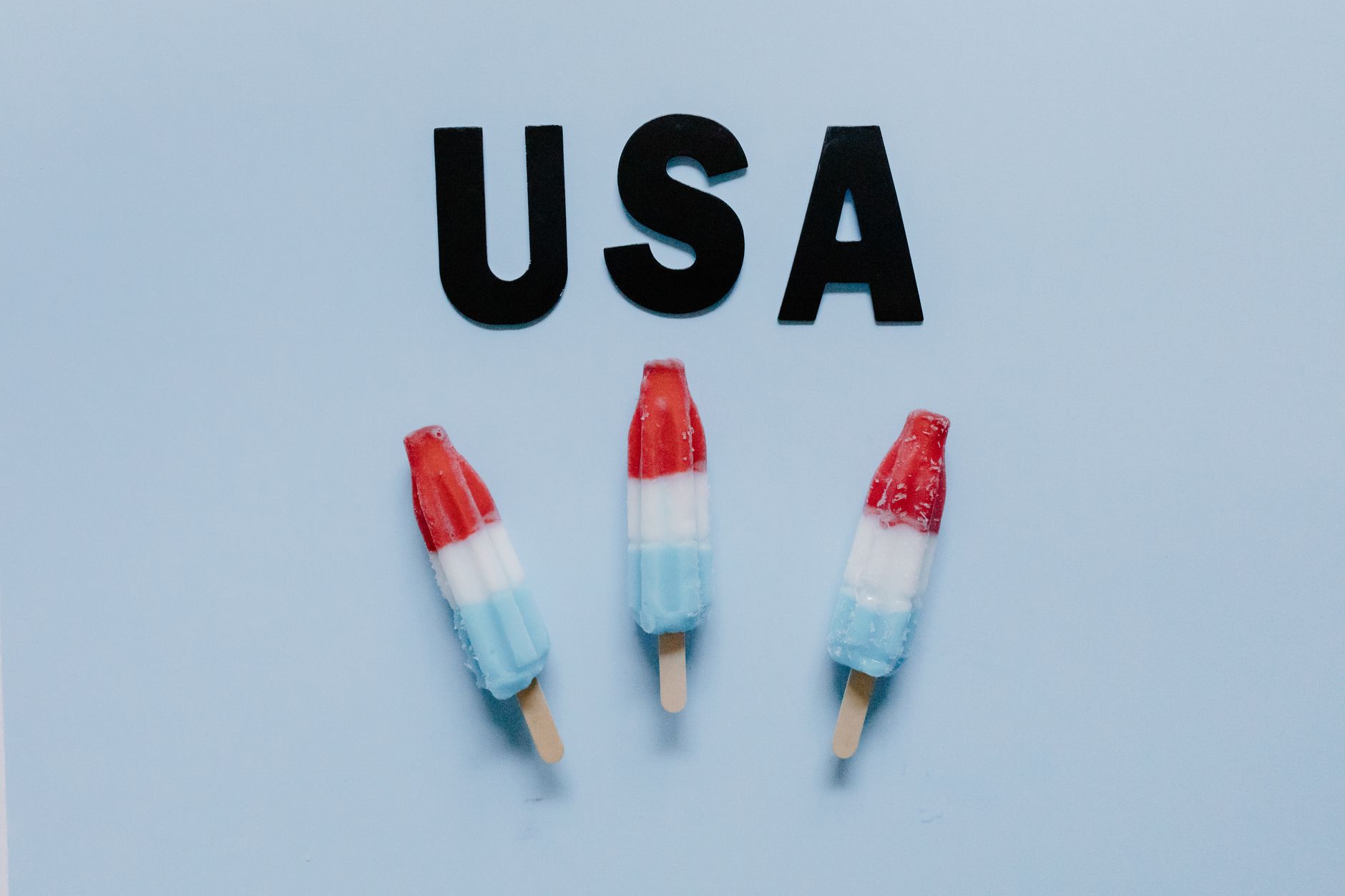 Sweet Summer Treats: Refreshing Drinks and Desserts Three red, white, and blue popsicles with USA text on a blue background, vector style.